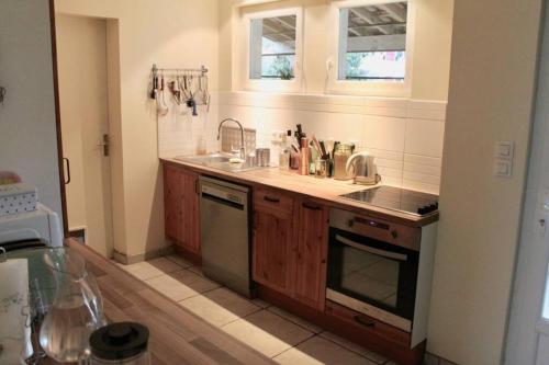 une cuisine avec un évier et une cuisinière dans l'établissement Grande Maison Familiale entre lac et océan, à Vielle-Saint-Girons