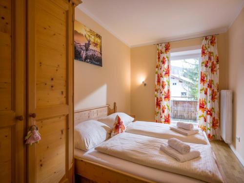 1 dormitorio con 1 cama con 2 toallas en Familienfreundliche Ferienwohnung im Thierseetal, FeWo 11, en Thiersee