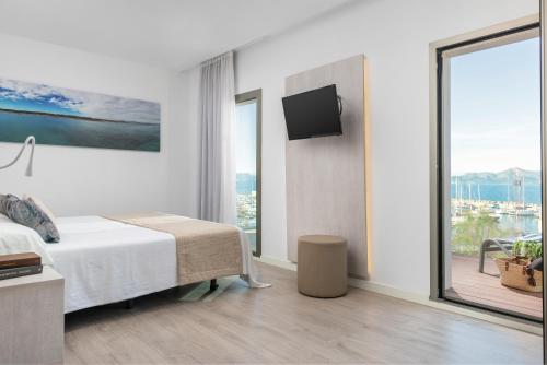 a bedroom with a bed and a large window at Llaut Boutique Hotel in Can Picafort