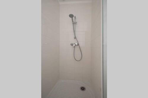 een douche met een douchekop in de badkamer bij Maison calme avec jardin et parking privés in Marsillargues