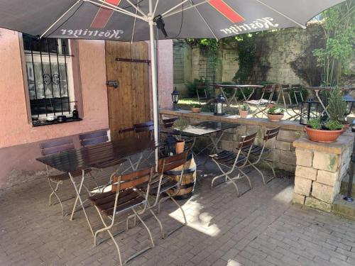 a table and chairs under an umbrella on a patio at Altes Brauhaus in Weißenfels