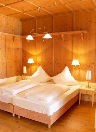 ヴェスターラントにあるSylter-Besserburg-App-1Pのベッドルーム1室(大型ベッド1台、テーブル2台、ランプ2つ付)