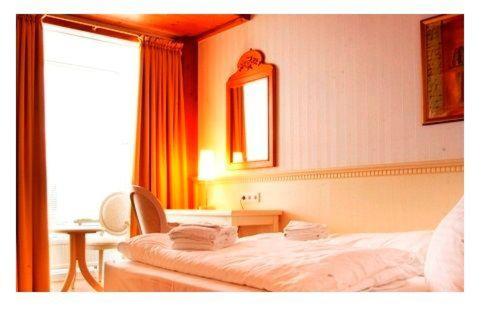 een slaapkamer met een bed, een bureau en een raam bij Sylter-Besserburg-App-1P in Westerland