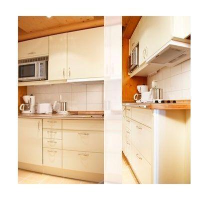 ヴェスターラントにあるSylter-Besserburg-App-1Pのキッチン(白いキャビネット、電子レンジ付)