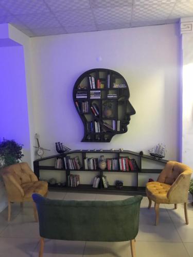 una habitación con una estantería de libros con una cabeza en la pared en Midyat GAP Hotel, en Midyat