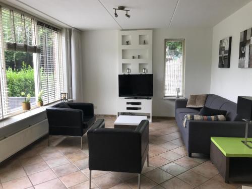a living room with a couch and a tv at 't Hulzen 55 or 61 Winterswijk in Winterswijk