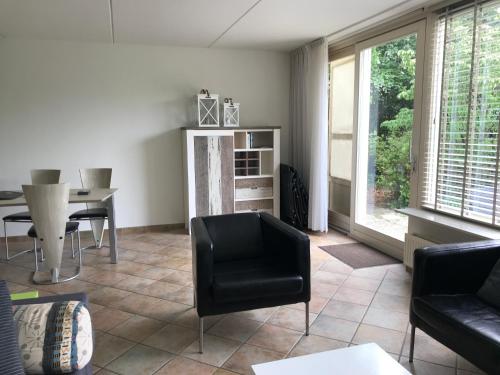 a living room with a black chair and a table at 't Hulzen 55 or 61 Winterswijk in Winterswijk