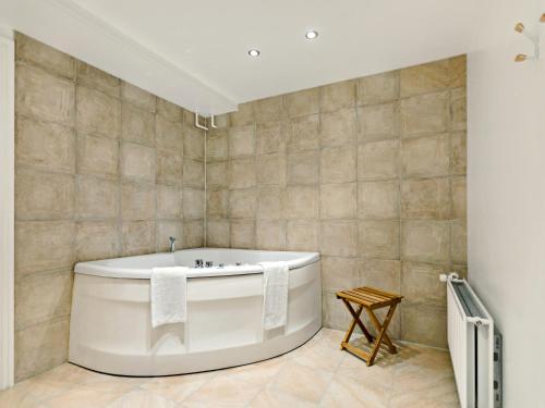 a white bath tub in a bathroom with tiles at Løgstør Parkhotel in Løgstør