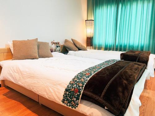 山中湖的住宿－Yamanaka Lake Ryozan，一间卧室配有两张床,床上有毯子