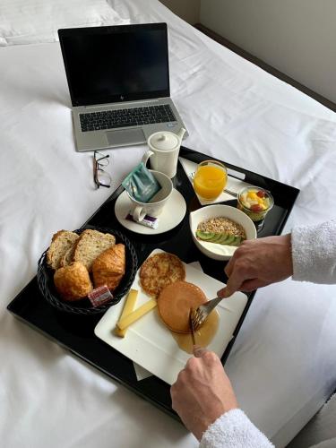 a tray of food on a table with a laptop at Mercure Cholet Centre in Cholet