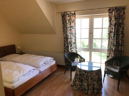 a bedroom with a bed and a window and a table at Gutshof Eucken in Algermissen