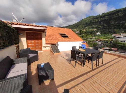 une terrasse avec une table et des chaises ainsi qu'une maison dans l'établissement Casa Fontana, à Sorrente