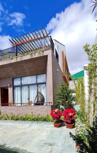 a house with flowers in front of it at Homestay My Ny Đà Lạt in Khu Chi Lăng