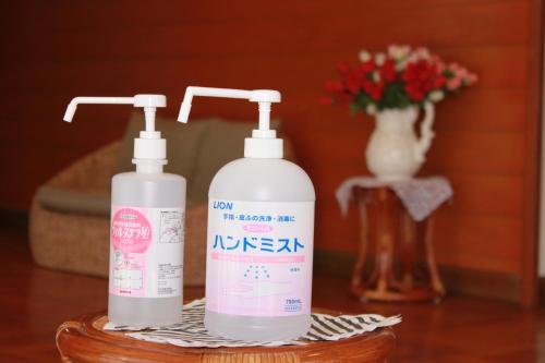 two bottles ofodorizers on a table with a vase of flowers at Yamanaka Lake Ryozan in Yamanakako