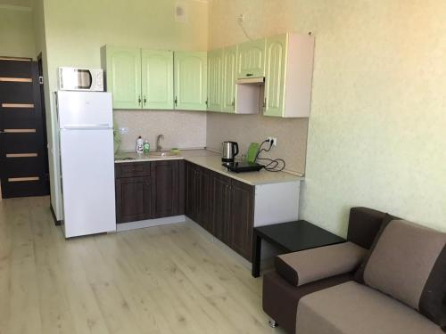 a kitchen with green cabinets and a white refrigerator at Улица Склизкова д116 к.6 in Tver