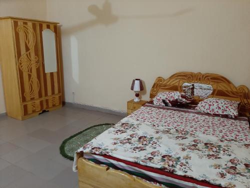 um quarto com uma cama e uma cómoda em madeira em Appartement chambre salon climatisées, cuisine em Bamako