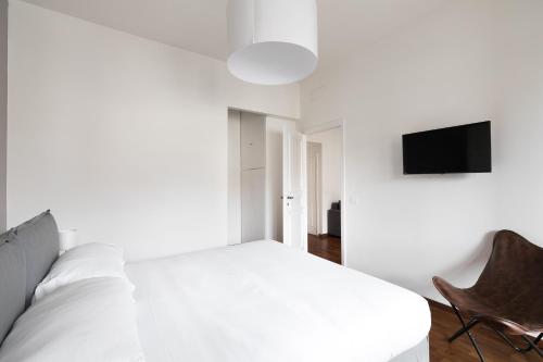 a white bedroom with a bed and a chair at Fleming 58 by Hili in Rome