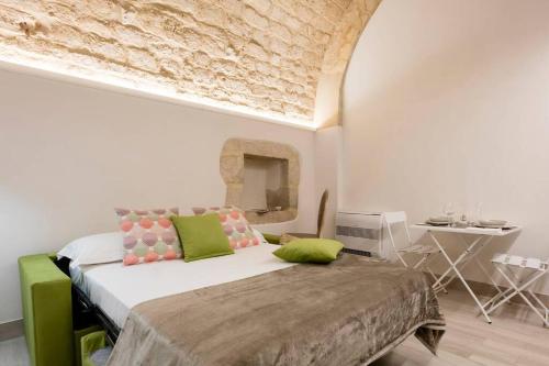 a bedroom with a bed with green and pink pillows at Atem Villa Sicily, Spa and Pool in Modica