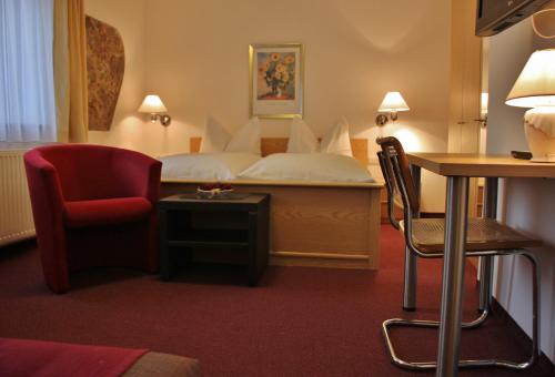 Habitación de hotel con cama y silla en Gasthof-Pension Zum Haugstein - Familie Eder, en Engelhartszell