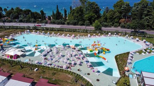an overhead view of a large swimming pool with people in it at Camping Cisano - San Vito in Bardolino