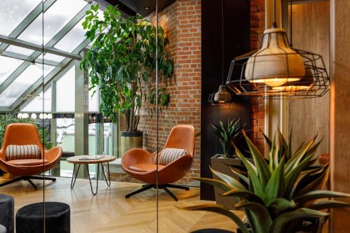 a lobby with orange chairs and plants at SCHUSTER Boarding House in Braşov