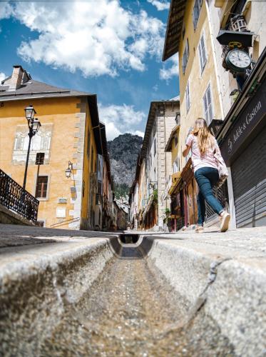 a woman riding a skateboard down a city street at SOWELL HOTELS Le Parc & Spa in Briançon