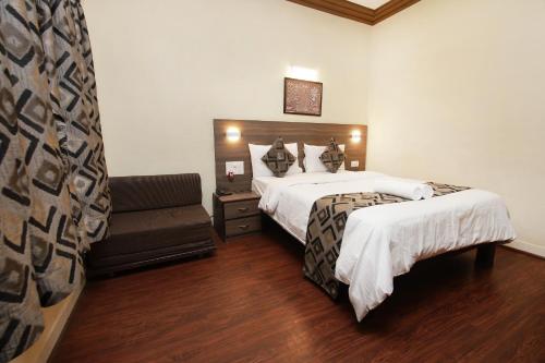 a hotel room with two beds and a couch at Westend Hotel in Matheran