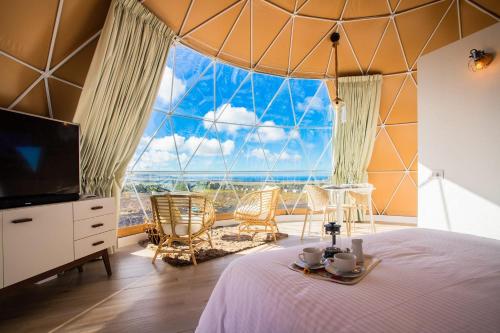 una habitación con una cama y una ventana grande en Eslanzarote Luxurious Eco Dome Experience, en Teguise