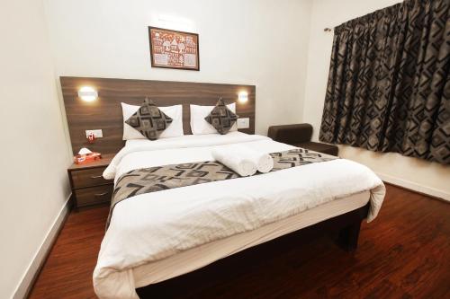 a bedroom with a large bed and a window at Westend Hotel in Matheran