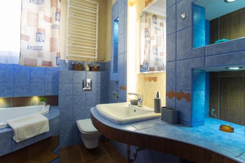 a blue tiled bathroom with a sink and a toilet at Apartament Bystry Centrum APARTZAKOP in Zakopane