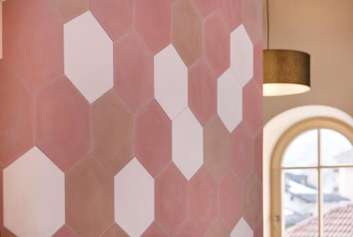 a bedroom with a hexagonal wall at Goldengel Design - Suiten im historischen Ortskern von Kaltern in Caldaro