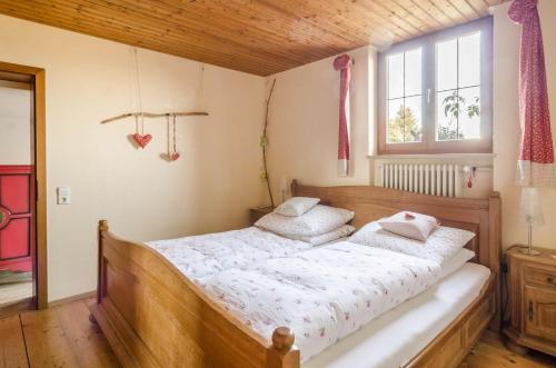a bedroom with a wooden bed with two pillows at Landhaus - In der hohen Eich Eg in Überlingen