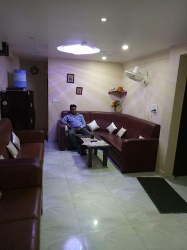 Vamoose Akshat Chindwara في Chhindwāra: رجل يجلس على أريكة في غرفة المعيشة