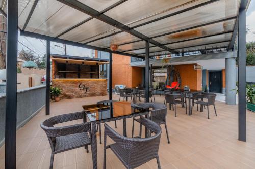 an outdoor patio with tables and chairs and a bar at Hotel Green Town in Kutaisi