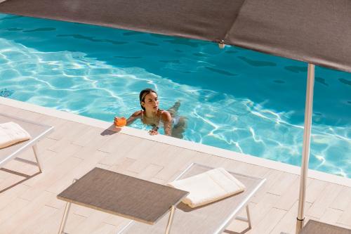 a woman is in a swimming pool at Atem Villa Sicily, Spa and Pool in Modica