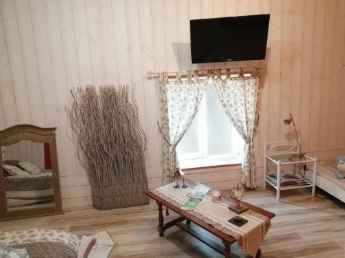 ein Wohnzimmer mit einem Tisch und einem TV an der Wand in der Unterkunft les tourterelles in Chabournay