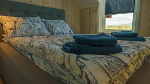 a bed with blue towels on it in a room at Lilleeideholmen Sjøhusutleie in Haug