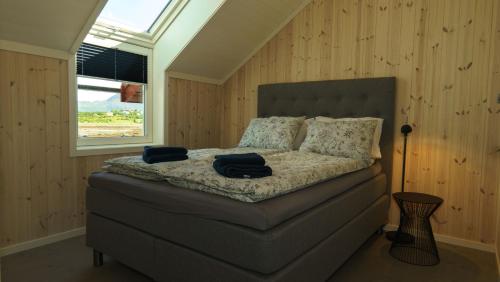 a bedroom with a bed with two pillows and a window at Lilleeideholmen Sjøhusutleie in Haug