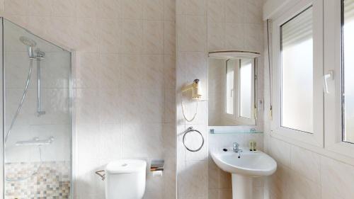 a bathroom with a sink and a toilet and a shower at Pensión Portomiño in Portomarin