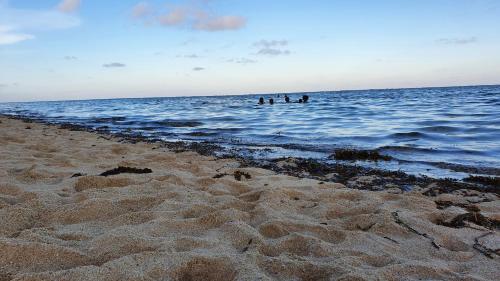 three people are in the water at the beach at Vipingo Ridge-Swahili Villa in Mombasa