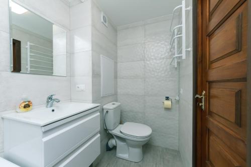 uma casa de banho branca com um WC e um lavatório em Уютная квартира на Лукьяновке em Kiev