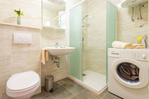 uma casa de banho com um WC, um lavatório e uma máquina de lavar roupa em Apartment Magnolia em Dubrovnik