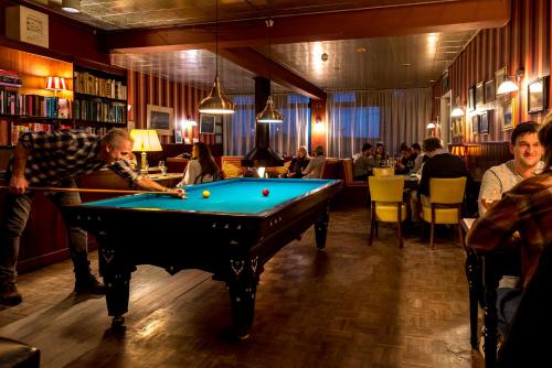 a man playing a game of pool in a pub at Loods Hotel Vlieland in Oost-Vlieland