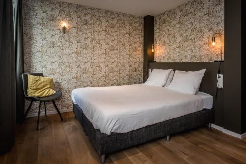 - une chambre avec un lit et une chaise dans l'établissement Loods Hotel Vlieland, à Oost-Vlieland
