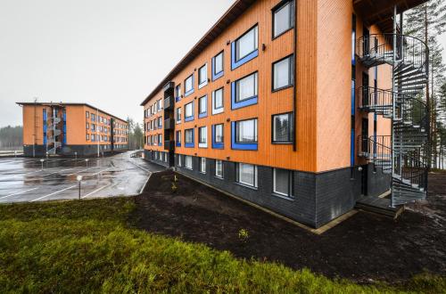 um parque de estacionamento vazio ao lado de um edifício de apartamentos em Vuokatti Sport Apartments em Vuokatti