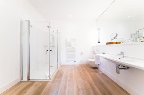a white bathroom with a white sink and white cabinets at Gräflicher Park Health & Balance Resort in Bad Driburg