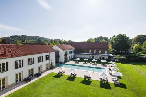 a large building with a pool and lawn chairs at Gräflicher Park Health & Balance Resort in Bad Driburg
