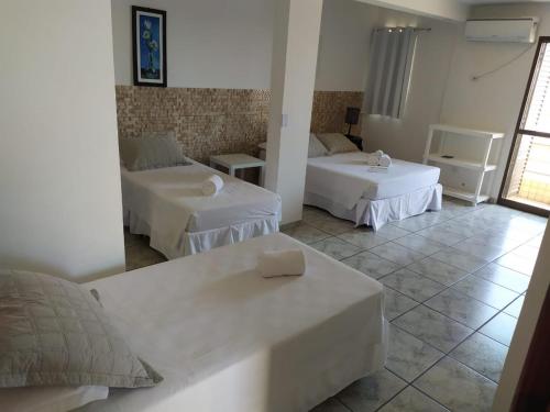 ein Hotelzimmer mit 2 Betten und einem Sofa in der Unterkunft Hotel Nautico in Guaratuba