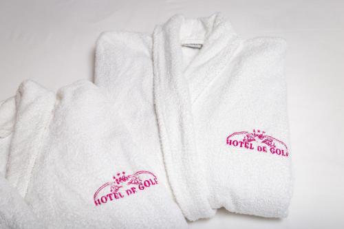 Deux serviettes blanches avec des logos de chaton sur elles dans l'établissement Hotel du Golfe, à Lomé