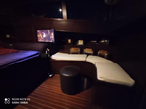 a room with a bed and a tv in it at Sabai Sabai Liveaboard Bangkok in Bangkok